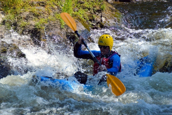 Kayaking down rapids in Wales